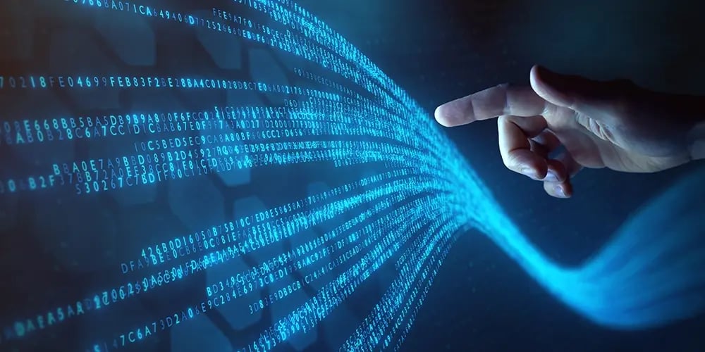 Hand pointing at flowing streams of glowing blue binary code on a dark digital background, representing data virtualization.