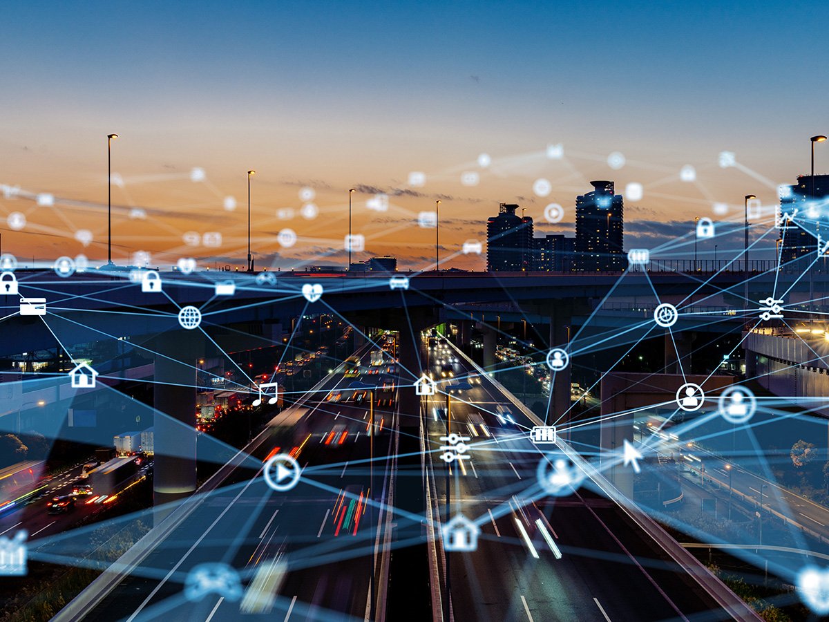 City highway at sunset with digital network icons and connection lines overlaid.