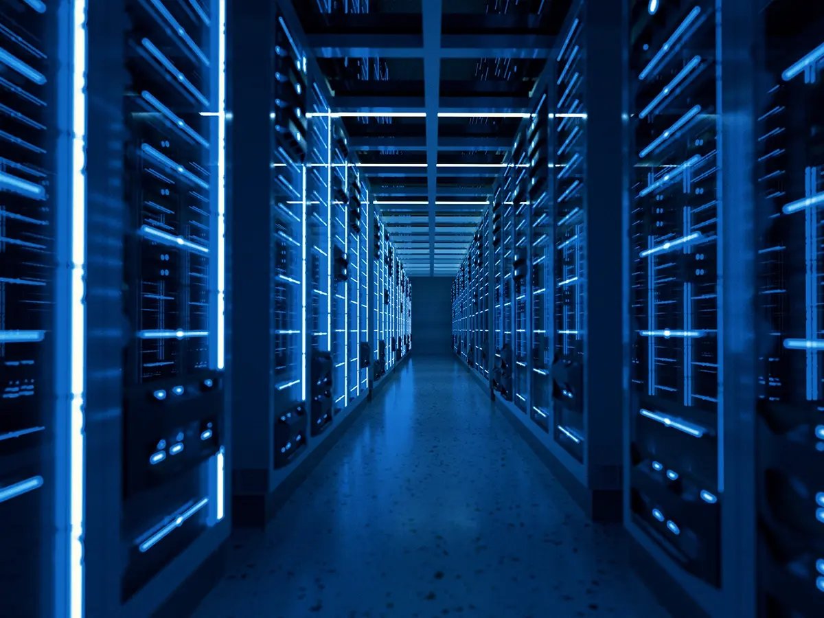 A glowing aisle of blue-lit server racks inside a modern data center.