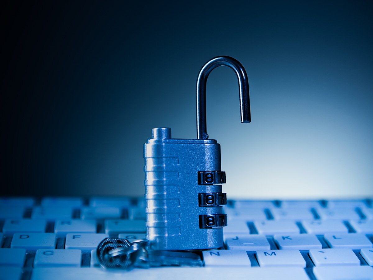 Open combination padlock resting on a computer keyboard.