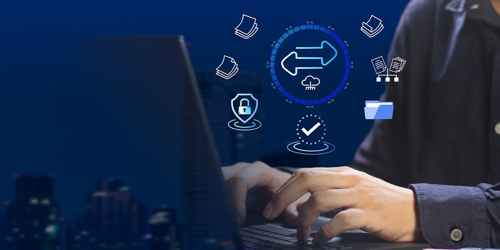 Hands typing on laptop with digital icons for file transfer and security.