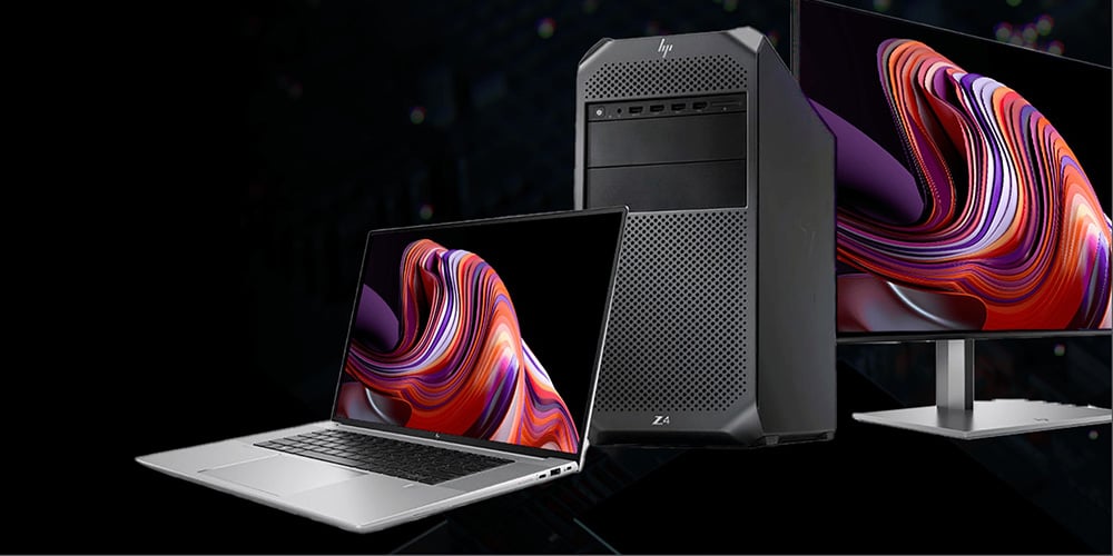 Laptop, desktop tower, and monitor displaying colorful abstract graphics.