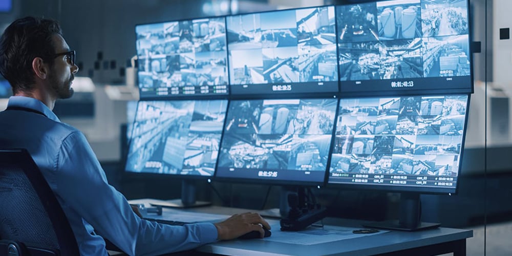 Multiple surveillance monitors showing camera feeds in a control room.