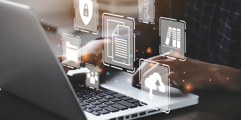 Hands typing on a laptop with floating digital icons, symbolizing automated processes for secure data erasure and management.