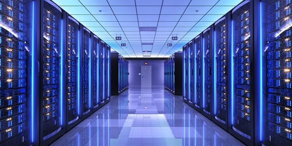 Rows of illuminated server racks in a data center, representing secure data erasure and management processes.