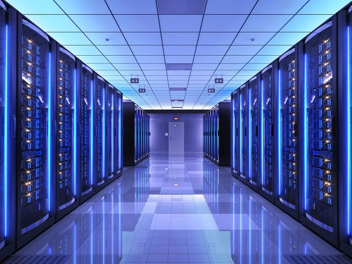 Rows of illuminated server racks in a data center, representing secure data erasure and management processes.