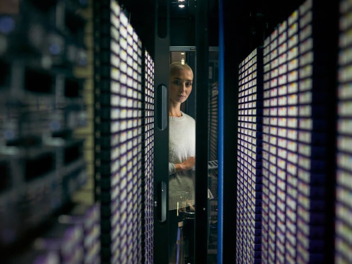 A person looking at a rack of data storage