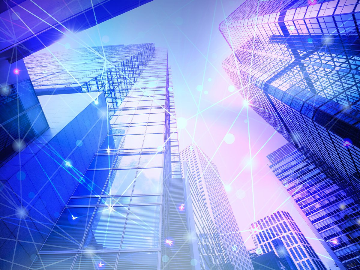 View of tall glass skyscrapers connected by glowing network lines, symbolizing digital connectivity.