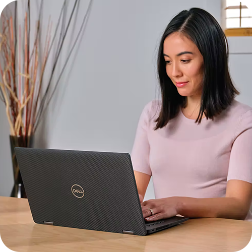 Person working on a laptop at a desk indoors.